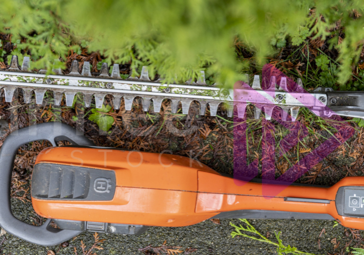 Close up of orange hedge trimmers laying on ground