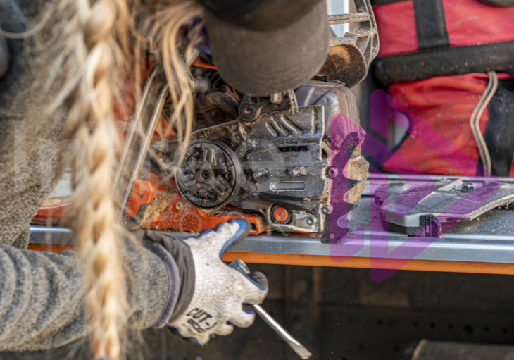 Woman cleaning and maintaining chainsaw