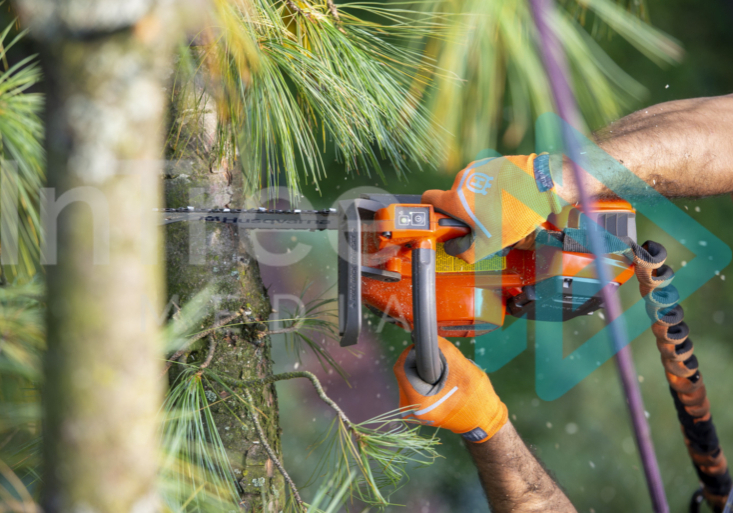 Battery powered saw in use with two gloved hands