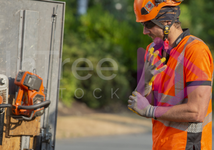 Man wearing orange hi-vis putting gloves on