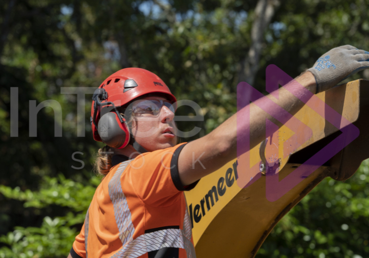 Man wearing red helmet adjusting chipper chute